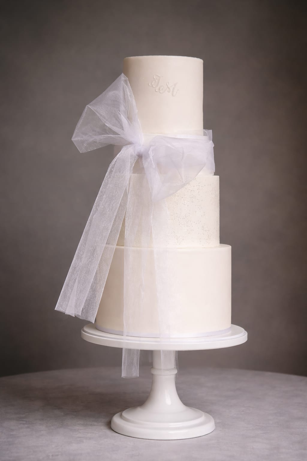 Three tier ivory textured bow wedding cake, Essex