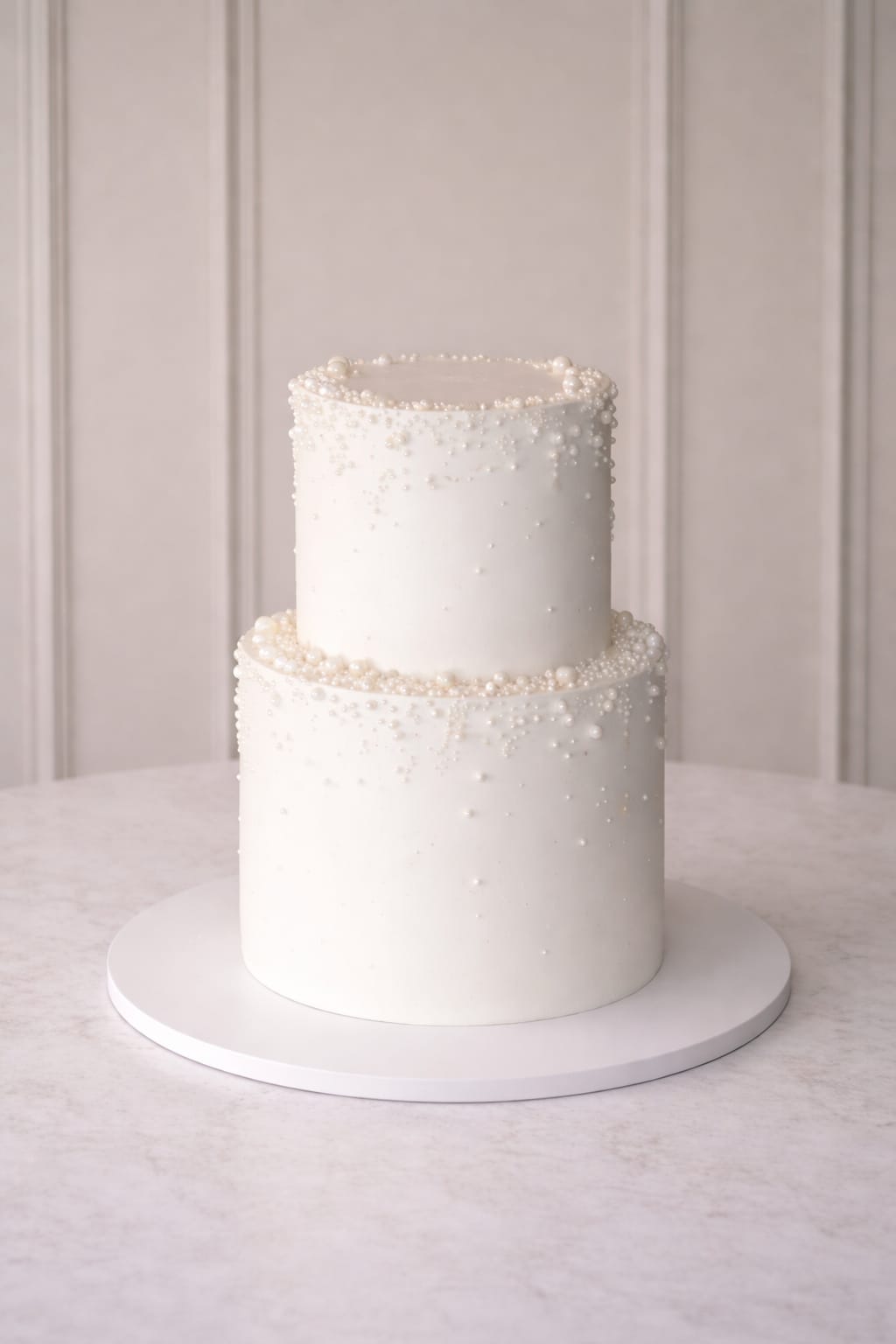 Two tier clean white wedding cake with pearls, Essex